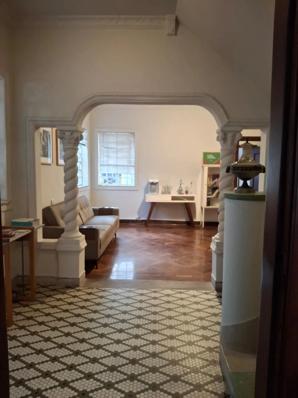 Hall de entrada da casa do Coletivo Feminista, com colunas em espiral e piso hidráulico